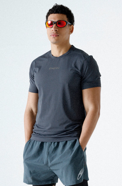 Man wearing a dark gray athletic outfit with sunglasses on a white background